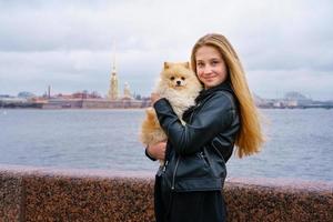 imagen de estilo de vida de una joven feliz y atractiva con chaqueta de cuero negro caminando foto