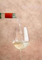 White wine pouring into glass photo