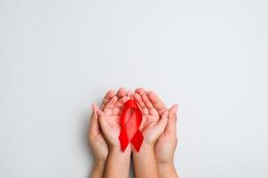 Hands holding red ribbon, hiv awareness concept photo