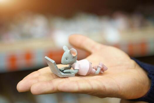 On the hand is a small figure of a mouse photo