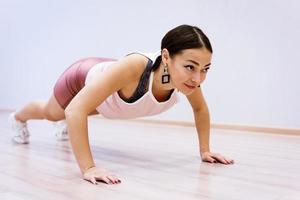 happy woman doing sports at home against wall background photo