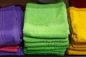 Multi-colored towels in stacks on the shelf in the store, photo