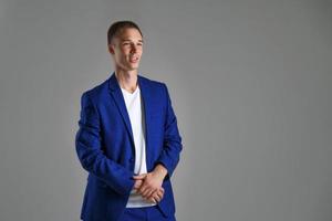 businessman in a blue jacket on a gray background look away photo