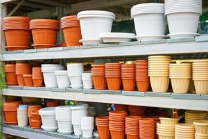 Plastic flower pots the shelf in the store stand, variety of sizes and colors photo