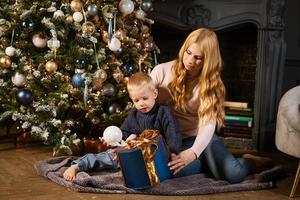 una familia de dos, madre e hijo, desempacando un regalo foto