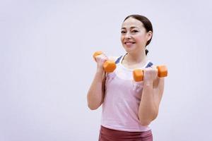 Woman in sportswear is engaged with dumbbells photo