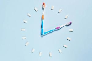 Toothbrushes and chewing gums making a clock photo