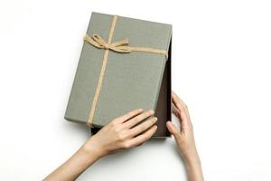 woman hand a grey gift box isolated on white background. photo