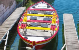 The colorful small boat parked to wooden pier. photo