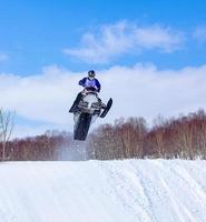 Snowmobile in high jump above track. photo