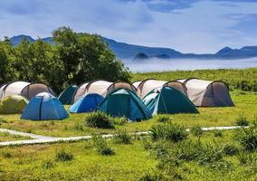 Tourists camped in the woods on the shore of the lake on the hillside. photo