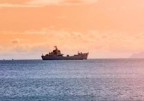 military ship on ocean at sunrise photo