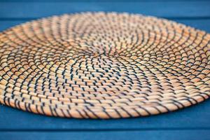 Wicker plate holde on table. Details of wicker plate. Selective focus photo