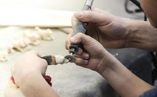 The male teacher and his little student make a hand-made walrus bone souvenir photo