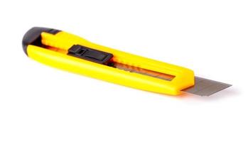 yellow stationery knife isolated on white background photo