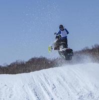 Snowmobile in high jump above track. photo