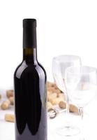 The Red wine glasses, bottle and corks. Isolated on white background photo