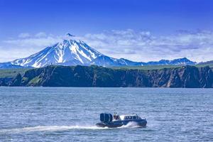 el aerodeslizador en el océano pacífico en la península de kamchatka en el volcán de fondo foto