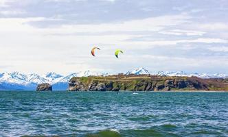The Kitesurfing, kiteboarding, kite surf. Extreme sport kitesurfing in Kamchatka Peninsula in the Pacific ocean photo