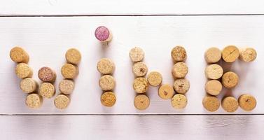 the inscription wine corks on white wooden background photo