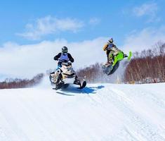 Snowmobile in high jump above track. photo