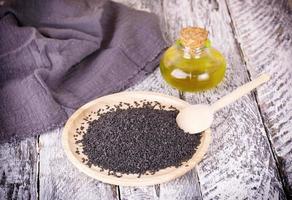 black sesame and oil on old wooden background photo