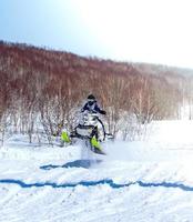 Snowmobile in high jump above track. photo