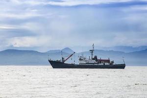 large fishing vessel on the background of hills