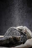 bread of unusual black color is sprinkled with flour photo