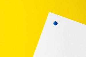 empty white card is pinned to yellow background photo