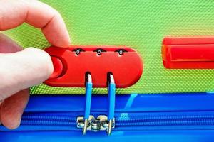 person opens a locking mechanism on the suitcase photo
