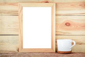 empty frame and white cup on a wooden background. photo