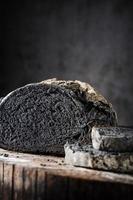 Sliced bread of black color on a wooden table photo