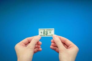 two woman's hands holding small banknote of 100 US dollar photo