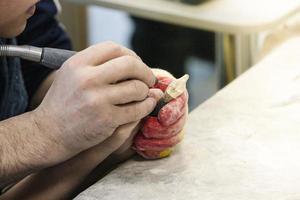 The male teacher and his little student make a hand-made walrus bone souvenir photo