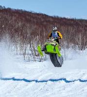 Snowmobile in high jump above track. Selective focus photo