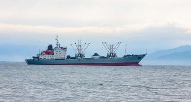 Trawler fishing boat sailing in ocean photo