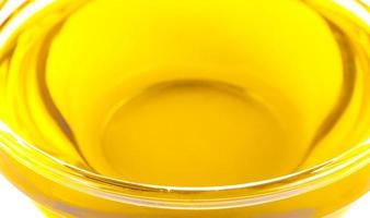 The Pouring cooking oil a small glass cup isolated on white background photo