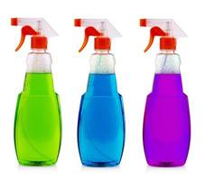 The colored spray bottle with liquid isolated on white background photo