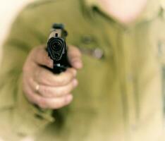 Man pointing gun at the target with one Hand photo