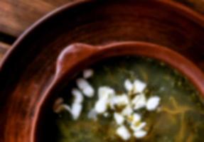 blurred background - a clay bowl of soup photo