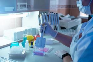 Woman scientist working in laboratory and examining biochemistry sample in test tube. Science technology research and development study concept. photo