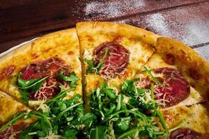 sliced pizza with beef and greens close-u photo