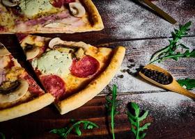 Italian fast food. Delicious hot pizza sliced and served on wooden platter with ingredients, close up view. Menu photo. photo