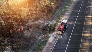 Cleaning the side of the road from shrubs and trees. photo