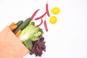 types of vegetables in paper bag isolated on white background photo