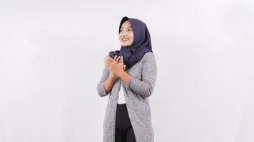 asian woman in hijab smiling while clapping isolated on white background photo