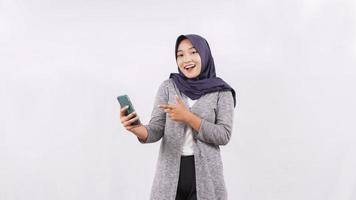 joven mujer asiática jugando smartphone felizmente aislado sobre fondo blanco foto