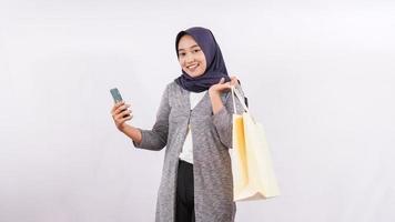 asian girl and shopping bag using smartphone and debit card isolated on white background photo