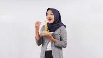 asian girl happily enjoying noodles isolated on white background photo